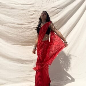 Pre-draped, slim fit saree in crimson chiffon with sequin embroidery. Styled with black sleeves sequin blouse